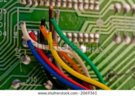 Colorful wires in front of a computer circuit-board