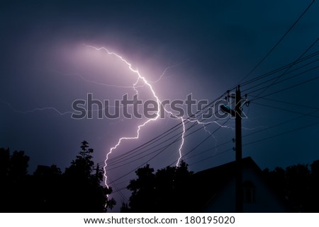 Lightning strike over a countryside house in night