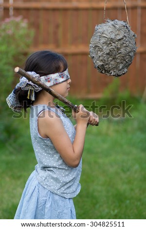 This is a girl about to whack a wasp nest pinata