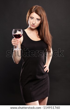 Young woman with glass of red wine.Dark background.