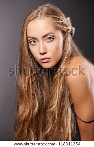 Beautiful blond girl posing. Dark  background.