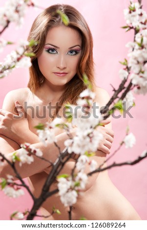 Portrait  of a gorgeous nude woman in apricot garden. Studio shot. Shallow DOF. Small amount of grain added .