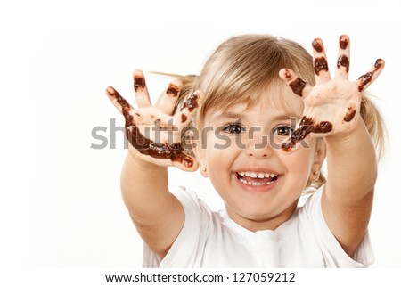 Small girl with chocolate smeared all over her face and fingers. - stock photo