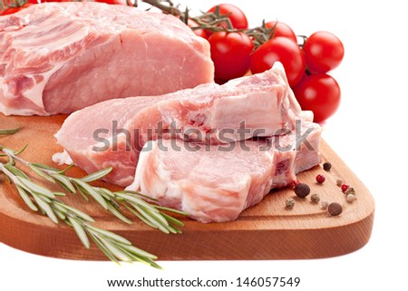 fresh row pork  with rosemary and spices on wood board isolated on white