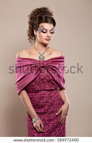 Young beautiful  brunette model in gorgeous dress burgundy color.Studio shooting.