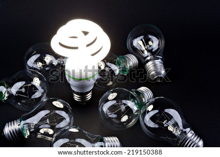 Incandescent light bulb with  fluorescent light bulb. Concept for energy conservation