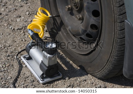 inflating tire by the electric pump on the roadside