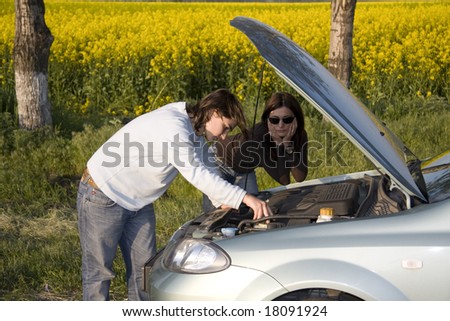 man and woman looking on the broken engine