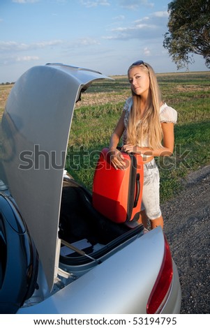 Woman near the car, with her baggage