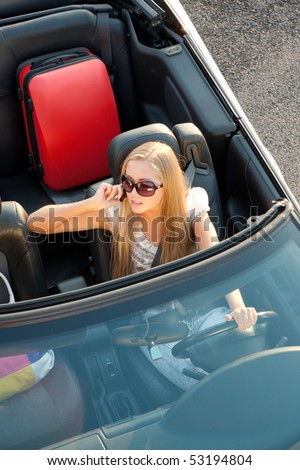 Woman sitting in a car, with her baggage