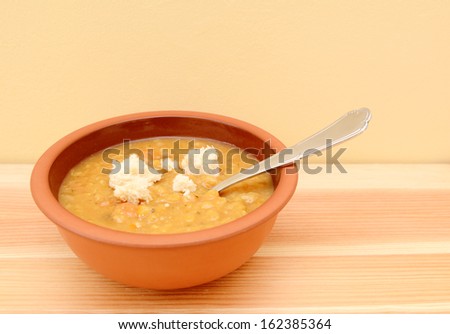 Bowl full of fresh vegetable soup with torn bread pieces on top