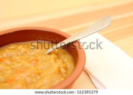 Closeup of hearty vegetable and lentil soup on a wooden table
