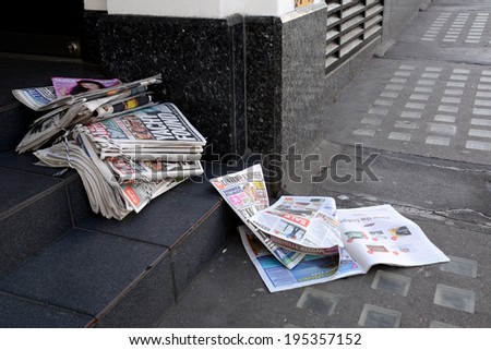 London, UK - May 25, 2014: Tabloid newspapers in a shop doorway on May 25, 2014. Headlines in the Daily Mirror report on the four sailors lost at sea when their yacht ran into trouble in the Atlantic.