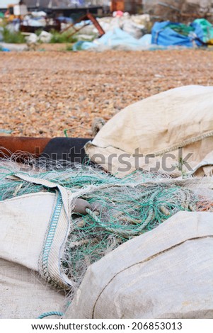 Large bags of nylon commercial fishing nets stored on a working beach in Hastings, England
