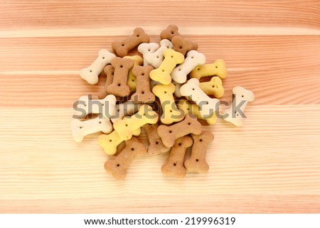 Heap of dried dog biscuits on a wood grain background