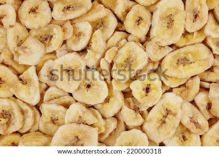 Yellow dried banana chips as an abstract background texture