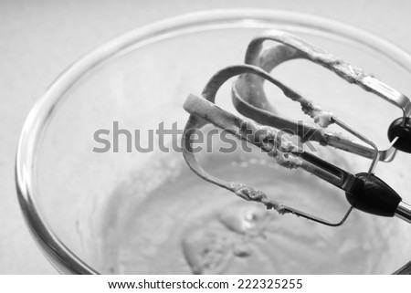 Hand mixer beaters mixing a smooth cookie dough batter - monochrome processing