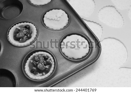 Process of making mince pies with pastry and traditional mincemeat filling - monochrome processing