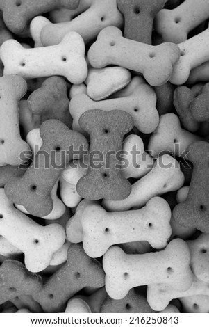 Mixed dog biscuits as a vertical abstract background texture - monochrome processing