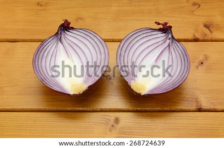 Red onion cut in half on a wooden table