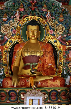 gilded metal statue of preaching Buddha in a Tibetan Buddhist monastery in Chandragiri, Orissa,India