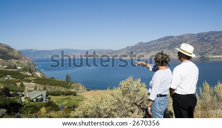 two tourists pointing at scenic viewpoint