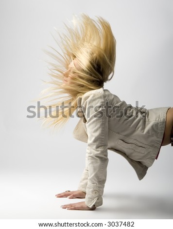 Young female model\'s long blonde hair flying up in the air