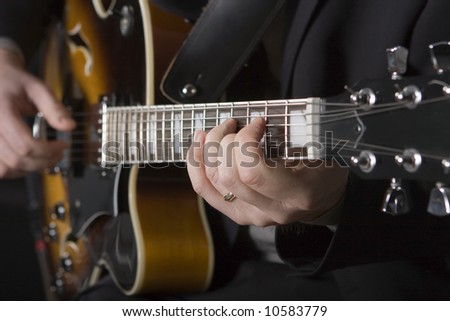 Close up view of man\'s hands playing electric guitar