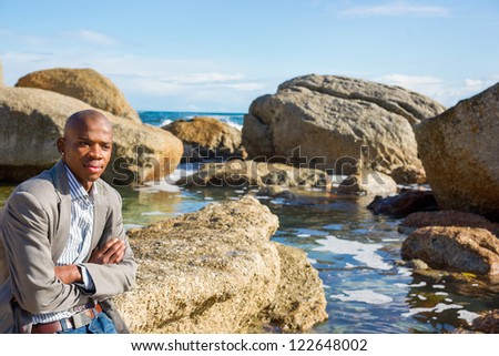 Young handsome african american man relaxing on the Cape Town beach located in South Africa