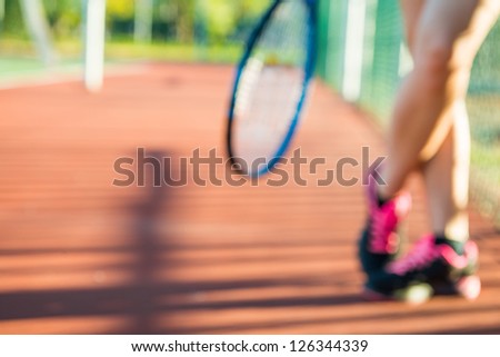 Young handsome woman playing tennis on court during hot sunny day in Cape town