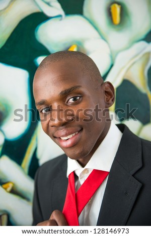 Young handsome african american man in suit shot outdoor in front of sprayed wall