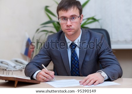 young businessman at his office signing document