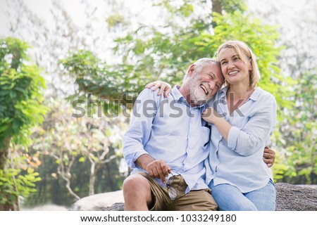Happy old couple smiling in a park on a sunny day, hoot senior couple relax in the forest spring summer time. Healthcare lifestyle retirement concept