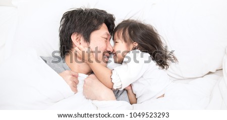 Father and daughter laughing and bonding in bed. Daddy and his little girl spending bed time at home. Single dad fun love family lifestyle father\'s day concept banner