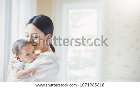 Close up portrait of beautiful young asian mother kissing her newborn baby. Healthcare and medical love lifestyle mother\'??s day concept