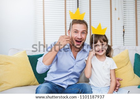 Portrait of dad and child daughter are playing and having fun together. Beautiful funny girl and daddy have crowns on sticks. Fun love family lifestyle single dad love father’s day holiday concept