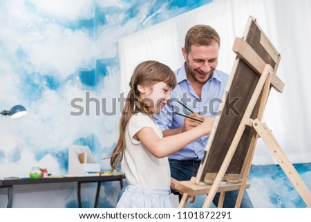 Portrait of caucasian father teach  daughter little artist girl to paint and draw picture art class. Home school learn from art teacher, education activities family love daddy father’s day concept.