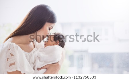 Closeup portrait of beautiful young asian mother kissing her newborn baby. Healthcare and medical family love lifestyle mother’s day concept panoramic banner