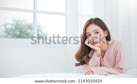 Portrait of beautiful asian woman feeling depress stress in bedroom. Sad face asian girl sitting near window in winter. Beauty treatment perfect clear skin japanese makeup  lifestyle concept banner