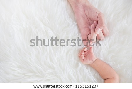 Asian parent hands holding newborn baby fingers, Closeup mother’s hand holding their new born baby. Together love harmony peace family nursery healthcare and medical father’s day concept banner