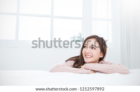 Portrait of young beautiful asian woman relax in her bedroom. Smile happy face asian girl look up on white background. Beauty treatment perfect clear skin japanese makeup relax lifestyle concept
