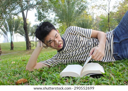 Young man reading the book in the park.