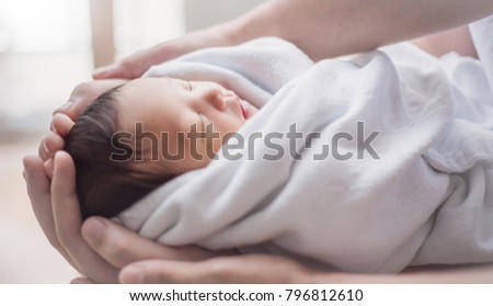 Close up father and mother hands holding newborn baby, copy space background banner family parents love sad concept
