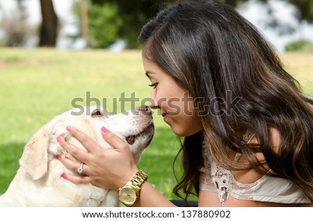 a happy looking woman nose to nose with her pet dog.