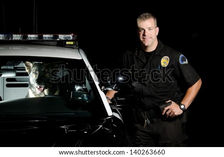 A K9 handler standing next to his patrol car with his partner in the driver seat.