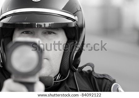 a police officer pointing his radar gun at speeding traffic.