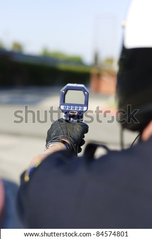 a motorcycle police officer aiming his radar gun a traffic.