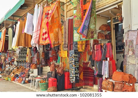 Variegated colors of oriental bazaar. The Arabian market in Jerusalem - bright motley fabrics and clothes are hung out for sale