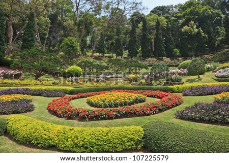 Huge picturesque landscape park in Thailand. Acacias and artly decorated flower beds