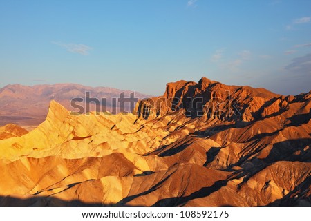 The well-known site of Death valley in California - the Zabriski-point. Picturesque hills of pink, yellow and chocolate shades on a sunset